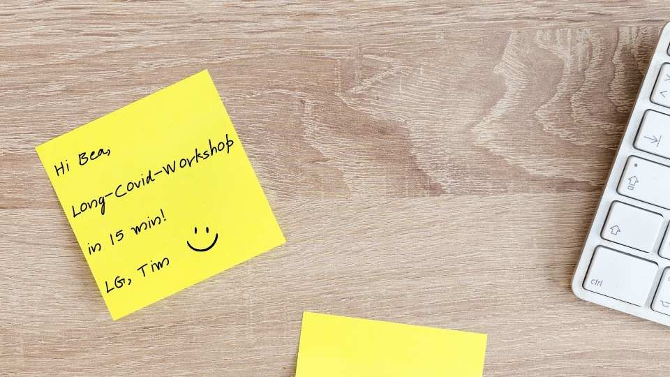 Notiz auf Schreibtisch mit den Worten "Hi Bea, Long-Covid-Workshop in 15 min. LG, Tim"