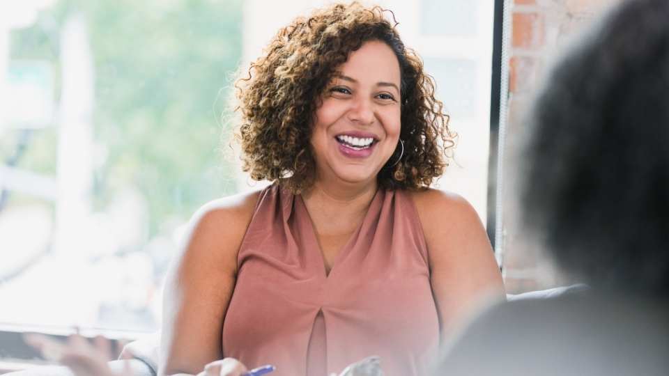 Lächelnde Frau spricht zu ihrem Gegenüber